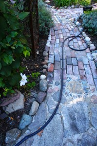 The new brick and field stone entrance to the Secret Garden. Note the single white clematis bloom a the lower left.
